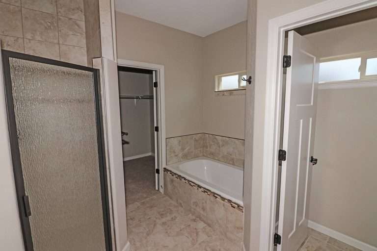 The Coral primary bathroom with shower and soaking tub, new home by Integrity Homes in Western Colorado