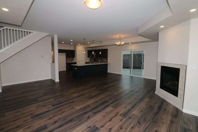 The Diamante great room with fireplace and kitchen, new home by Integrity Homes in Western Colorado