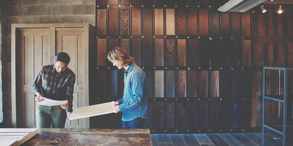 Two people reviewing flooring samples at a builder design center appointment.